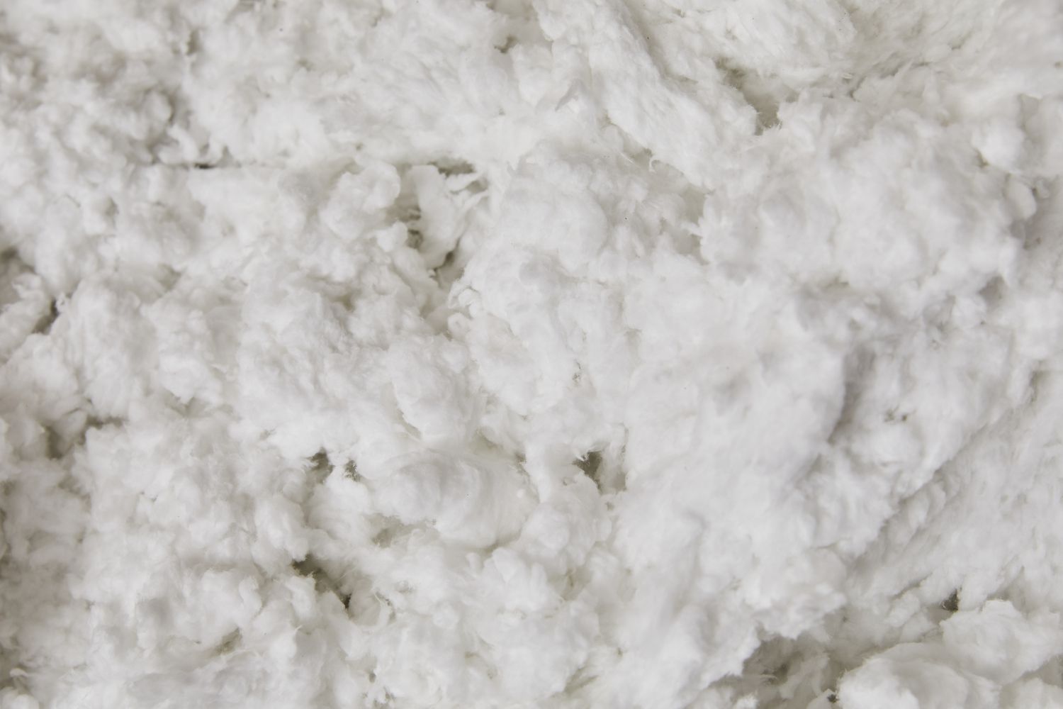 Professional insulation contractor using specialized equipment to blow dense-pack cellulose insulation into residential attic space, achieving high R-value thermal resistance for traditional home energy efficiency upgrade comparing costs versus smart glass technology - InfoProds 2026