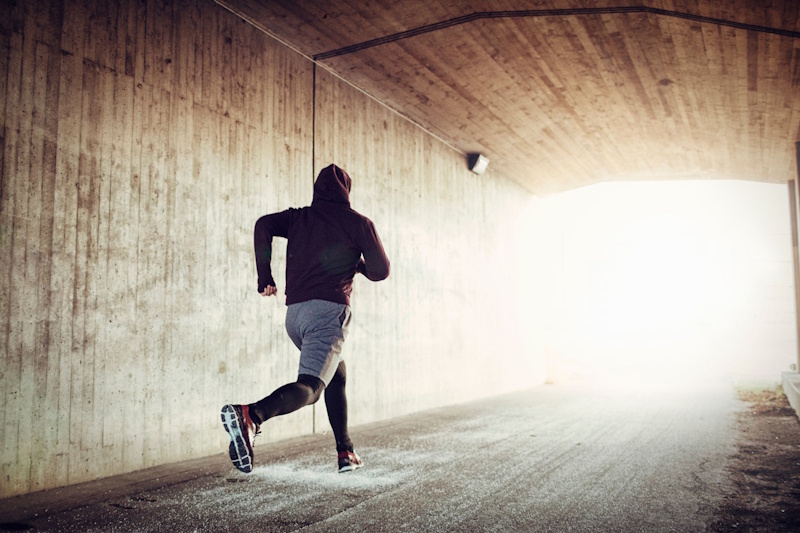 Person performing barbell squat exercise with proper form demonstrating fundamental strength training movement pattern for lower body development