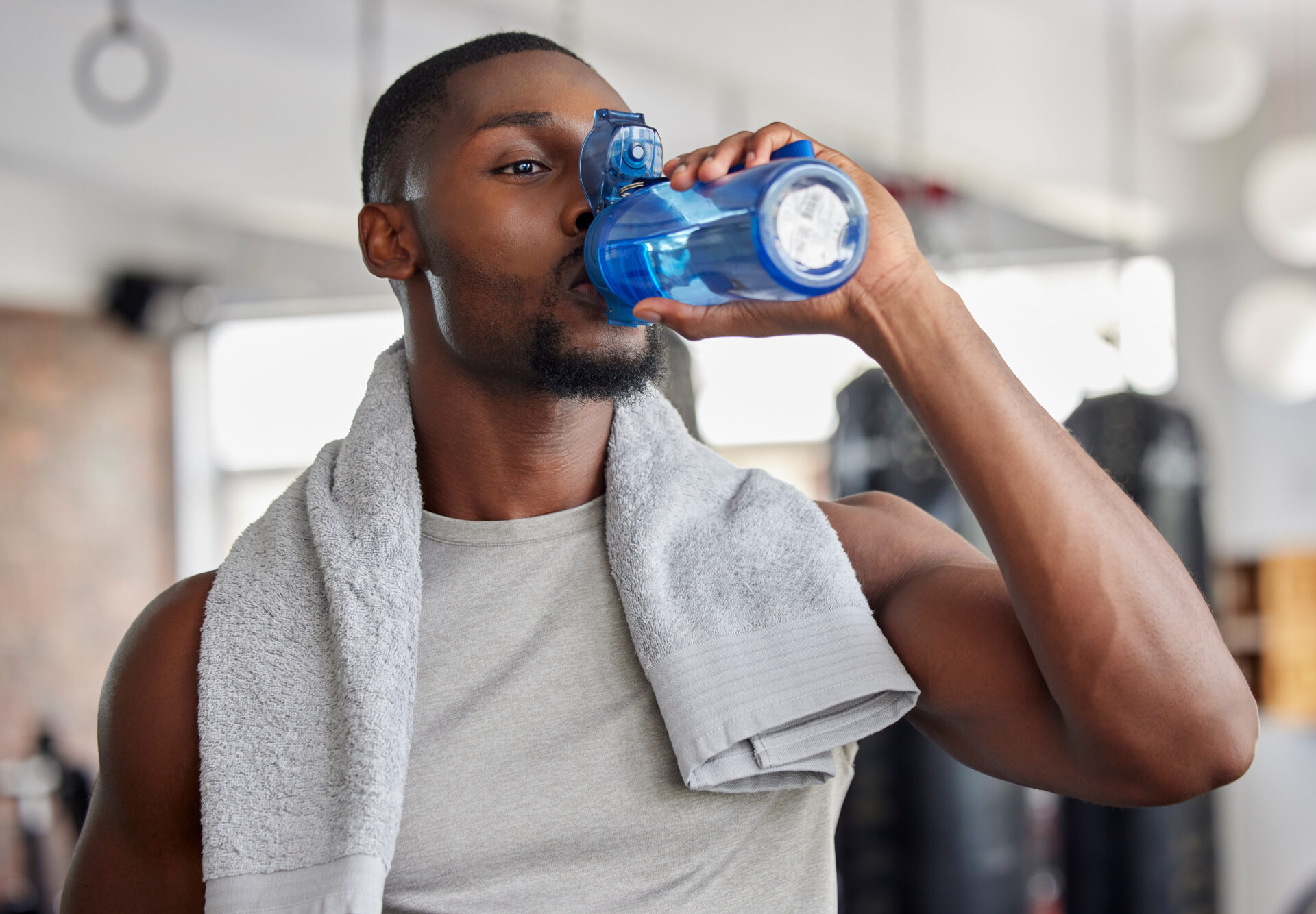 Athlete drinking water showing proper hydration strategies for sports performance and recovery
