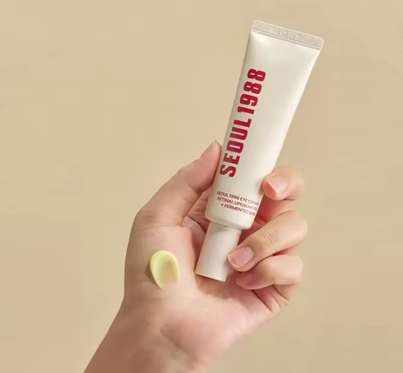 "Retinol anti-aging serum bottle with dropper applying golden serum to woman's face for wrinkle reduction and collagen production"