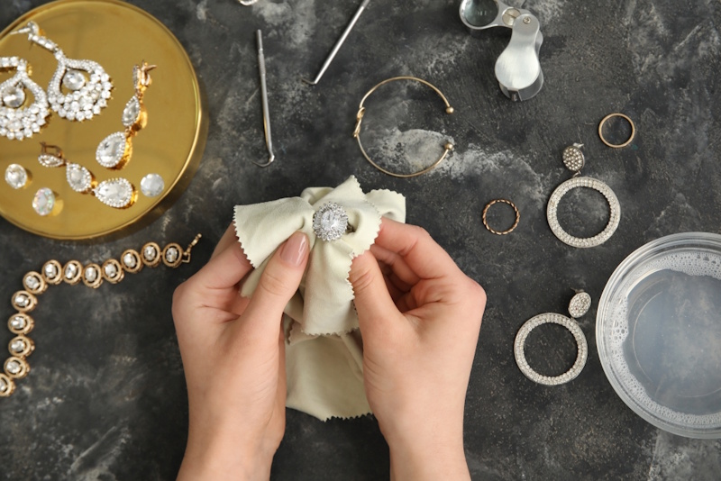 Diamond ring being gently cleaned with soft brush in soapy water demonstrating proper at-home jewelry cleaning method