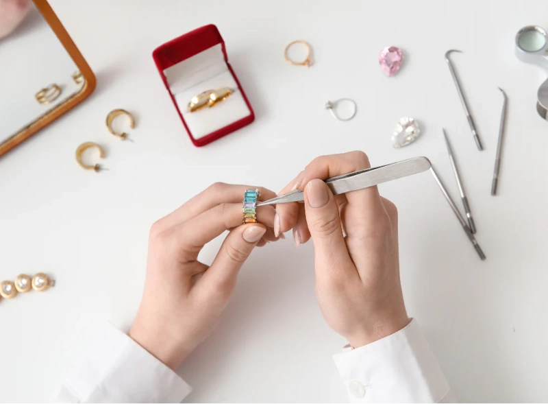 Professional jeweler examining diamond ring settings with loupe showing importance of regular jewelry inspection