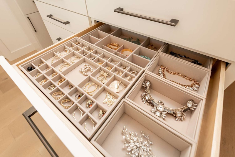 Organized jewelry box with separated compartments storing rings necklaces and earrings preventing damage and tangling