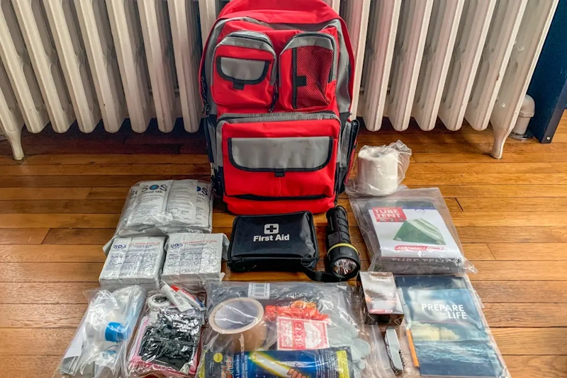Complete budget survival gear kit laid out showing affordable emergency supplies including water filters fire starters shelter tools and first aid under 200 dollars - survival kit InfoProds 2026