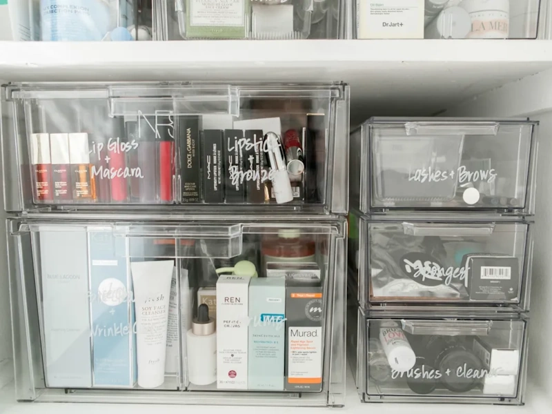 Professional makeup organizer drawer system with clear acrylic compartments, labeled cosmetics sorted by category, proper storage solution preventing expiration, beauty organization ideas - InfoProds 2026