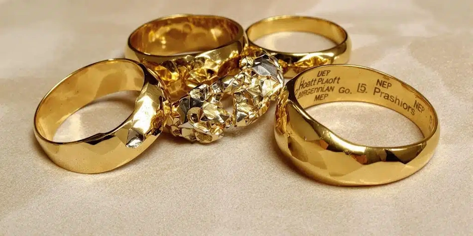 Collection of heavy chunky gold bracelets and chains demonstrating how jewelry weight creates value perception despite varying gold purity levels InfoProds 2026