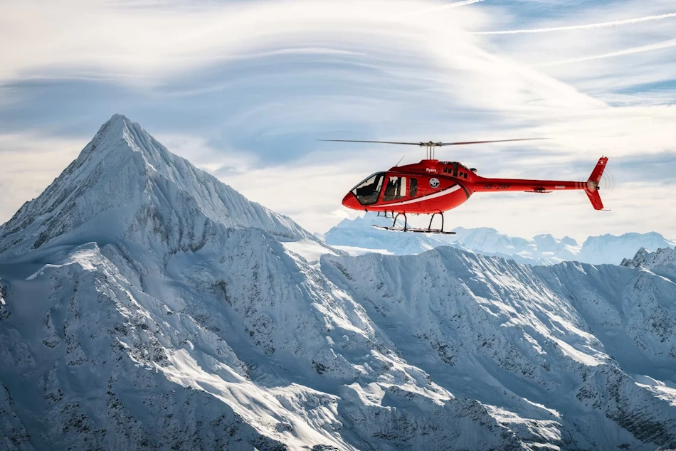 Search and rescue helicopter flying over snow-covered terrain using thermal imaging and GPS technology to locate stranded vehicles during winter storm emergency response operations - InfoProds 2026