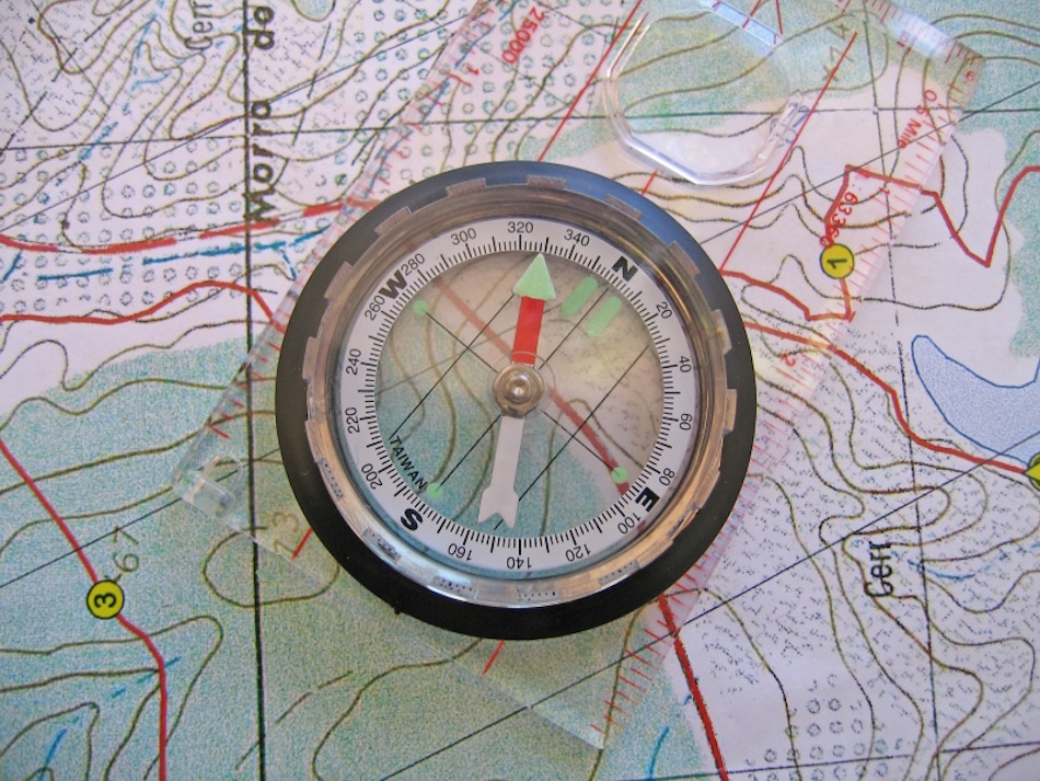 Advanced navigation technique showing triangulation process using compass bearings to multiple mountain peaks for determining precise location on topographic map during backcountry travel - InfoProds 2026
