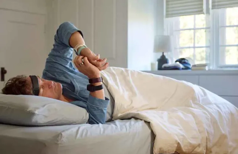 Person sleeping deeply in dark bedroom wearing fitness tracker monitoring sleep stages and heart rate for optimal fat burning metabolism and recovery - InfoProds 2026