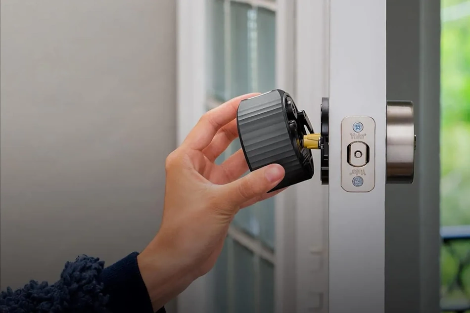 Homeowner installing optical charging smart lock replacing traditional deadbolt using basic Phillips screwdriver demonstrating simple DIY installation process requiring no permanent home modifications ideal for renters and apartment dwellers seeking reversible smart home security upgrades - InfoProds 2026