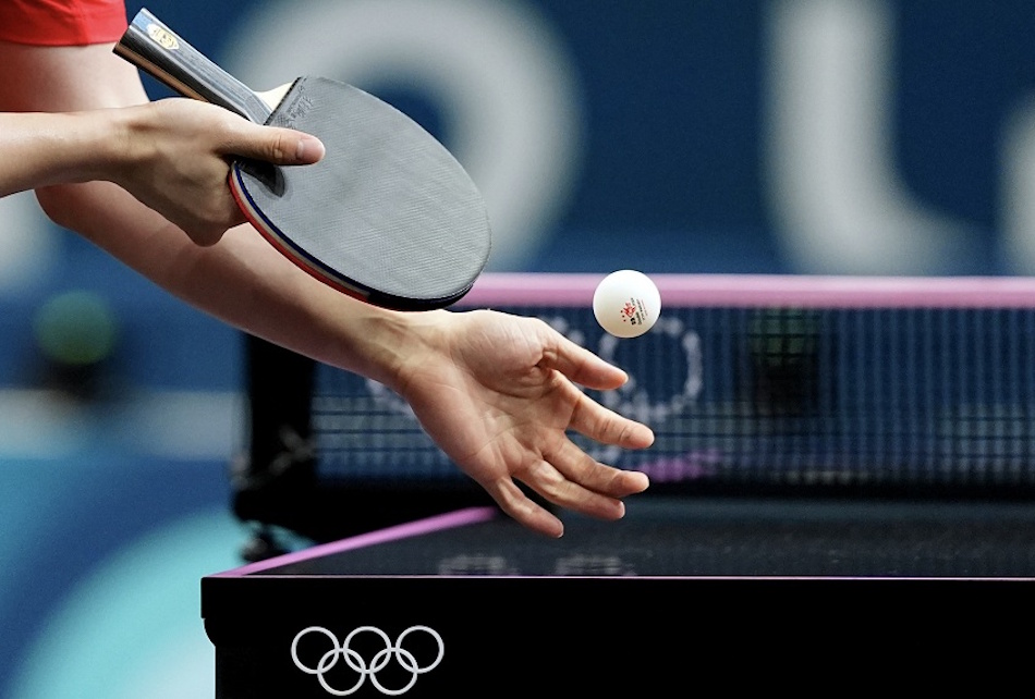 Elite competitive table tennis player executing powerful topspin stroke with professional-grade paddle featuring ITTF-approved premium rubber technology demonstrating advanced technique and equipment synergy during international tournament match - InfoProds Professional Sports Performance 2026