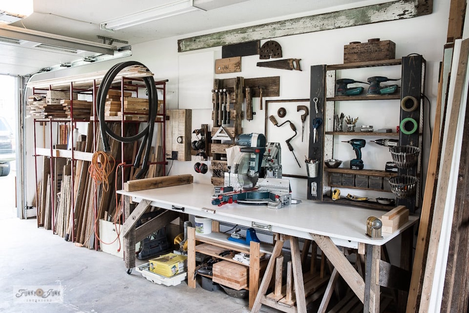 A beautifully organized secret garage workshop featuring a wall-mounted folding workbench, pegboard tool storage, and overhead ceiling racks while maintaining clear parking space — InfoProds 2026 guide to dual-purpose garage design