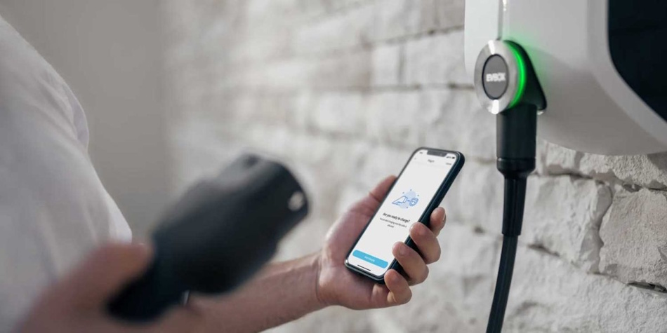 Smart EV charger with WiFi connectivity displaying smartphone app interface for scheduling, monitoring, and controlling residential charging sessions and energy usage - InfoProds 2026