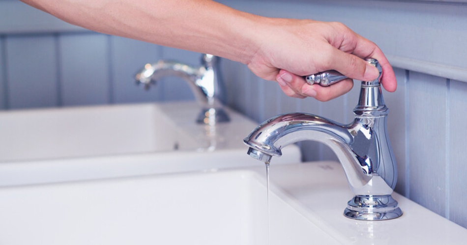 Kitchen sink with two basin setup showing proper hand washing technique with hot soapy water in first basin and cold rinse water in second basin for maximum water efficiency without running tap - InfoProds 2026 sustainable dishwashing guide