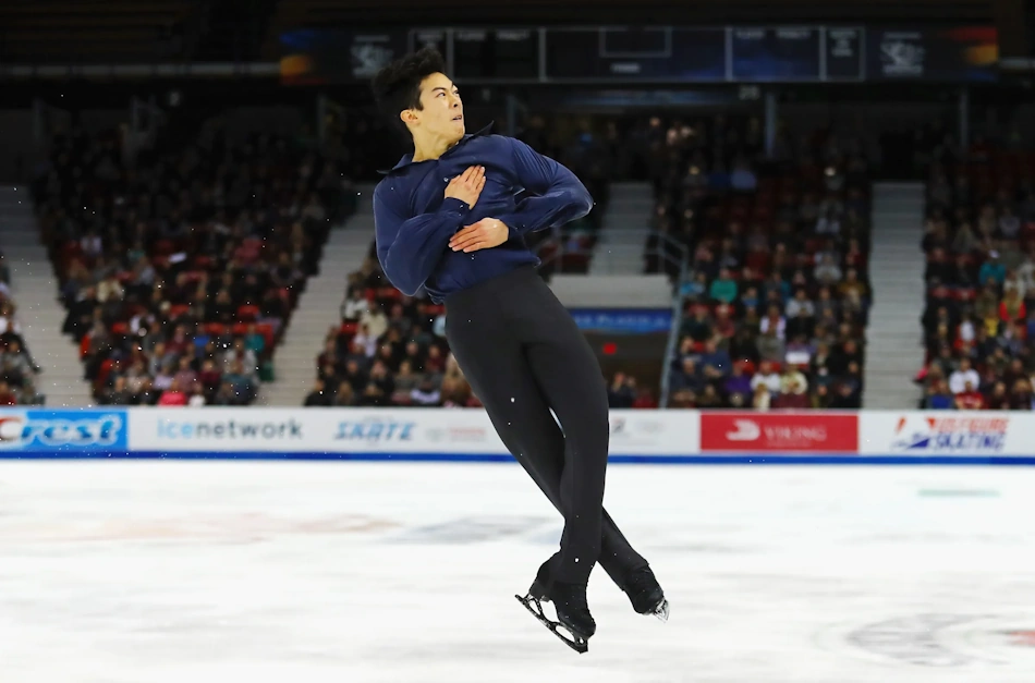 Professional figure skater executing high-speed quadruple rotation aerial jump demonstrating extraordinary vestibular system balance and spatial orientation capabilities developed through years of Olympic-level training - InfoProds Sports Science 2026