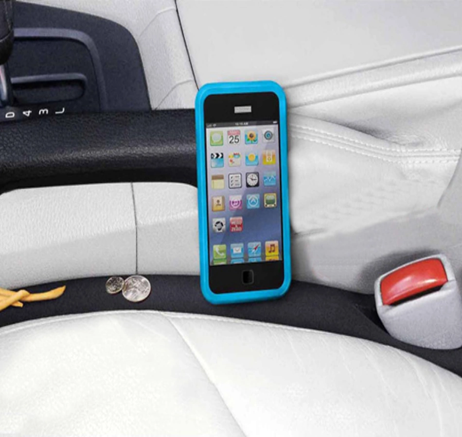 Modern car seat gap filler preventing smartphone from disappearing between driver seat and center console, showing protective barrier blocking the notorious gap where phones, keys, and valuables typically vanish in vehicles, featuring premium leather material matching automotive interior - InfoProds 2026