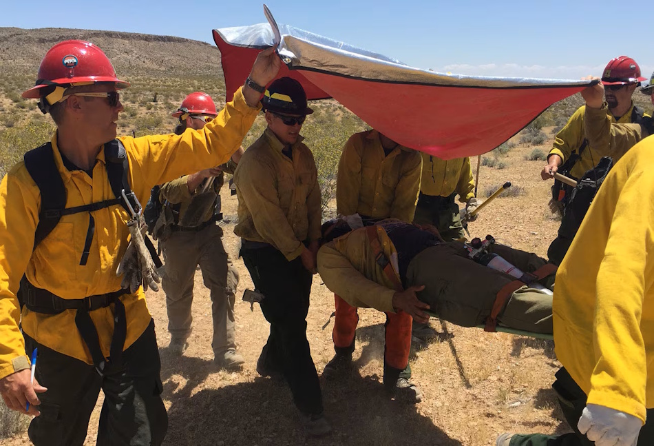 Wilderness first aid emergency response showing rapid cooling treatment for suspected heatstroke victim with wet towels and shade during hiking emergency, demonstrating critical life-saving intervention techniques for heat-related medical emergencies on outdoor trails - InfoProds 2026