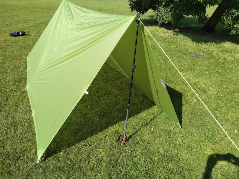 Properly pitched A-frame tarp shelter demonstrating effective rain shedding with 45-degree slope angles and adequate ground clearance during sustained precipitation testing showing water runoff patterns and waterproof performance - InfoProds Survival Equipment Analysis 2026