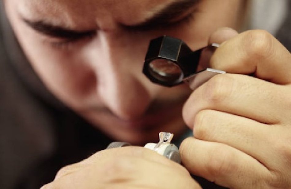 Professional jeweler using magnifying loupe to inspect necklace clasp for wear patterns, metal fatigue, and early failure signs during preventive maintenance examination - InfoProds 2026
