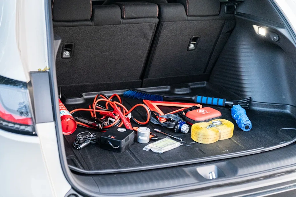 Vehicle trunk interior showing typical hot storage environment where summer temperatures exceed 160°F accelerating chemical degradation of jump starter cables through plasticizer evaporation copper oxidation and insulation embrittlement reducing safe service life - InfoProds Vehicle Storage Safety 2026