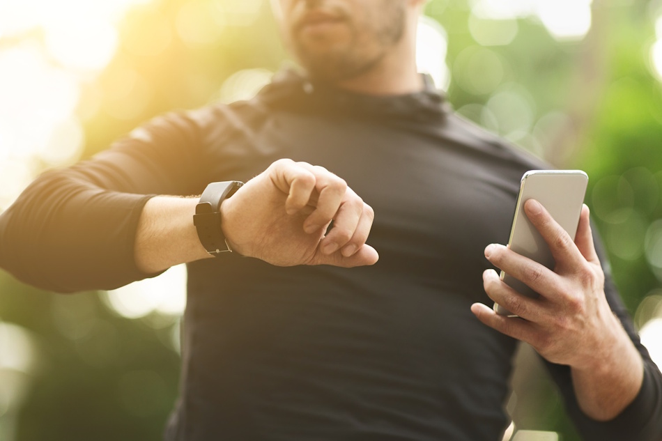 Fitness enthusiast analyzing walking versus running statistics on smartwatch display showing calories burned, distance traveled, and heart rate metrics for evidence-based weight loss comparison - InfoProds 2026