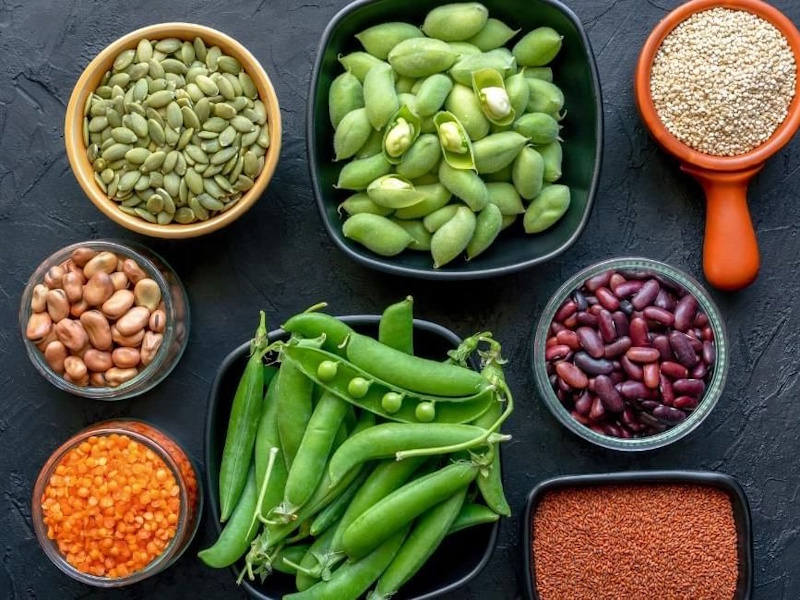 Variety of whole food protein sources including eggs, chicken breast, fish, legumes, nuts, and Greek yogurt arranged displaying complete nutrition for natural muscle building without supplements - InfoProds 2026