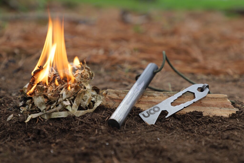Close up view of ferro rod producing bright orange sparks during wet weather fire starting demonstration showing reliable ignition capability in rain conditions essential survival skill for outdoor emergency preparedness wilderness camping scenarios InfoProds 2026